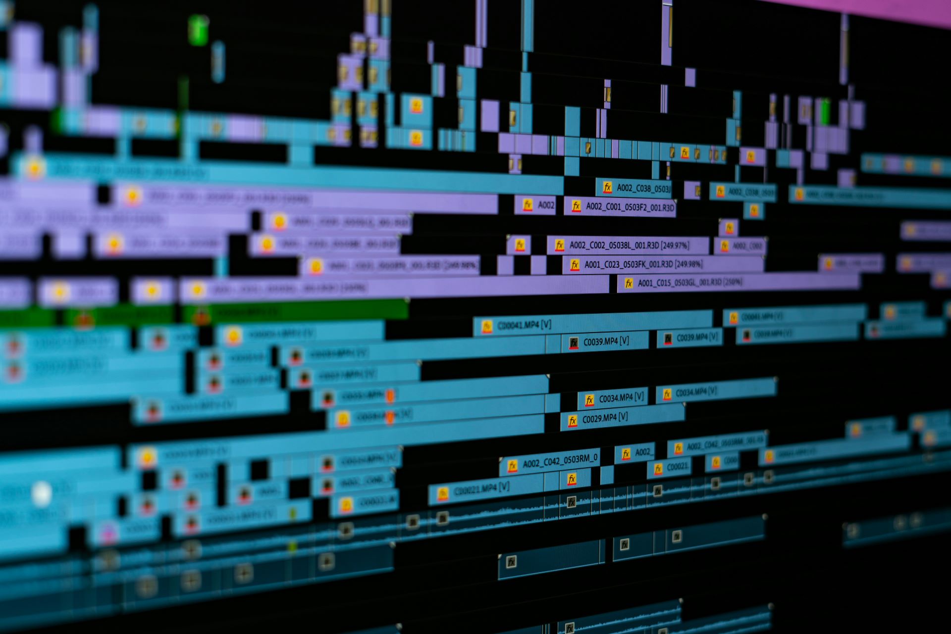 A closeup of a series of video clips on a timeline in a video editing software.