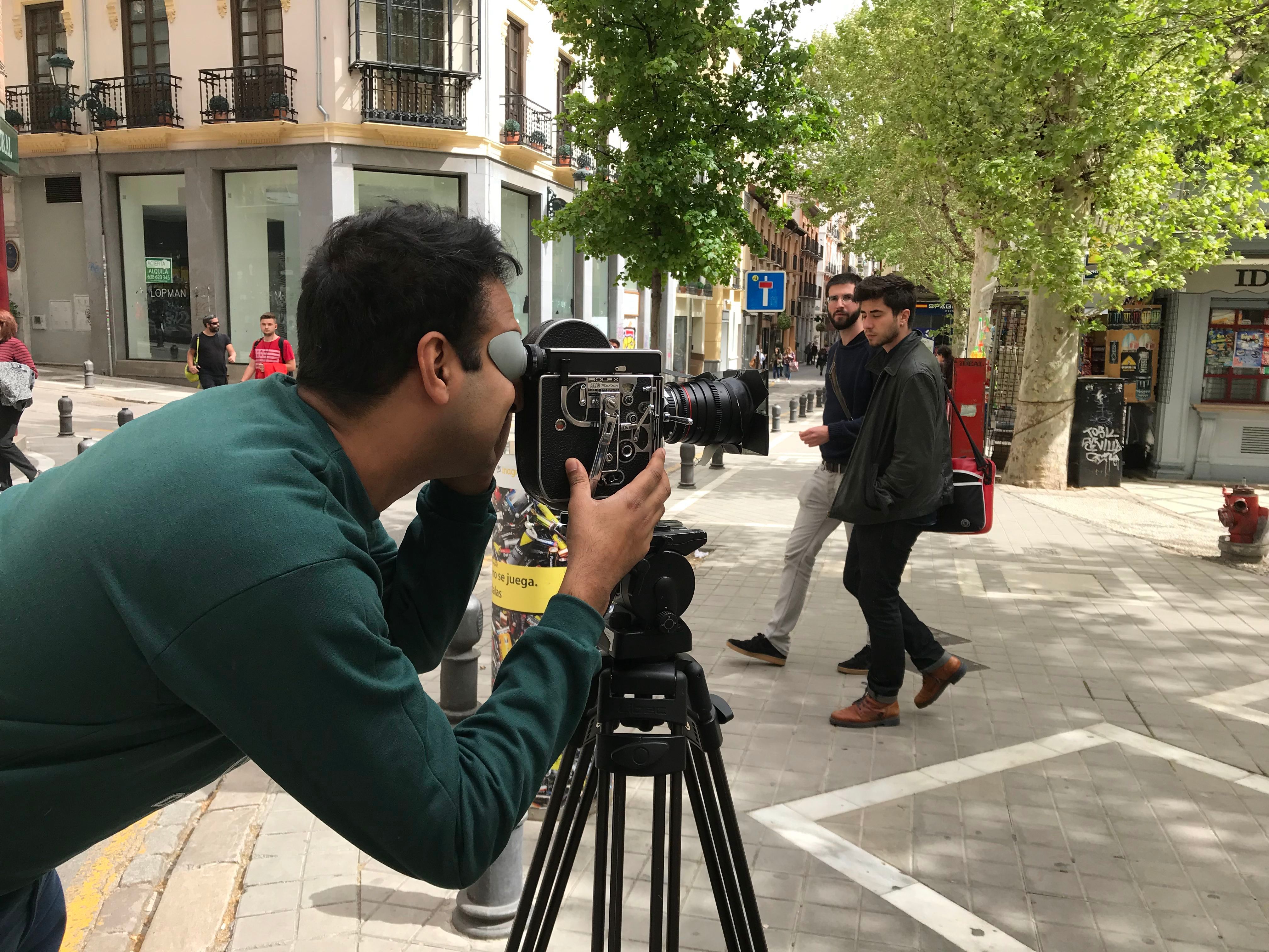 Man stands in front of a camera in centre of a town