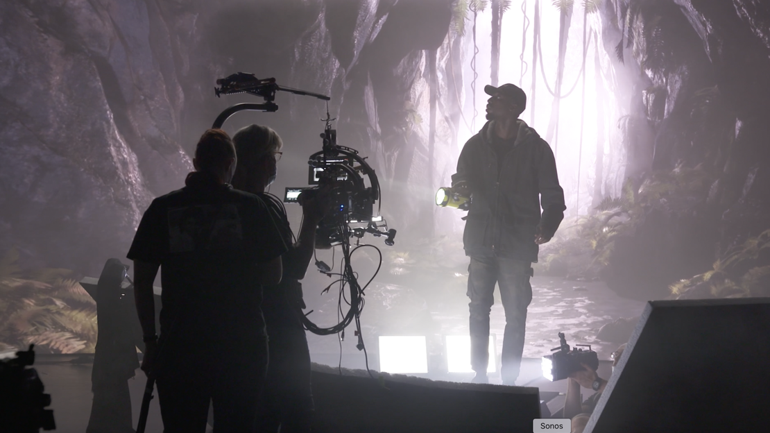 Man walking with a torch on a virtual production stage with camera operator in front