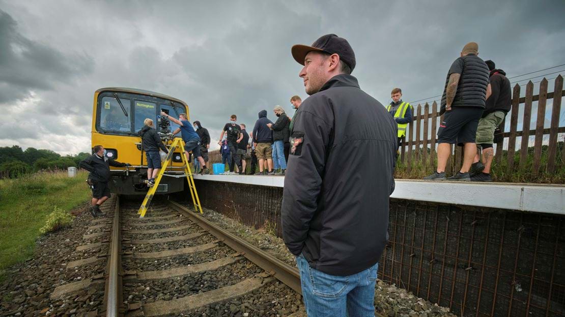 Man standing on railway track being used for filming