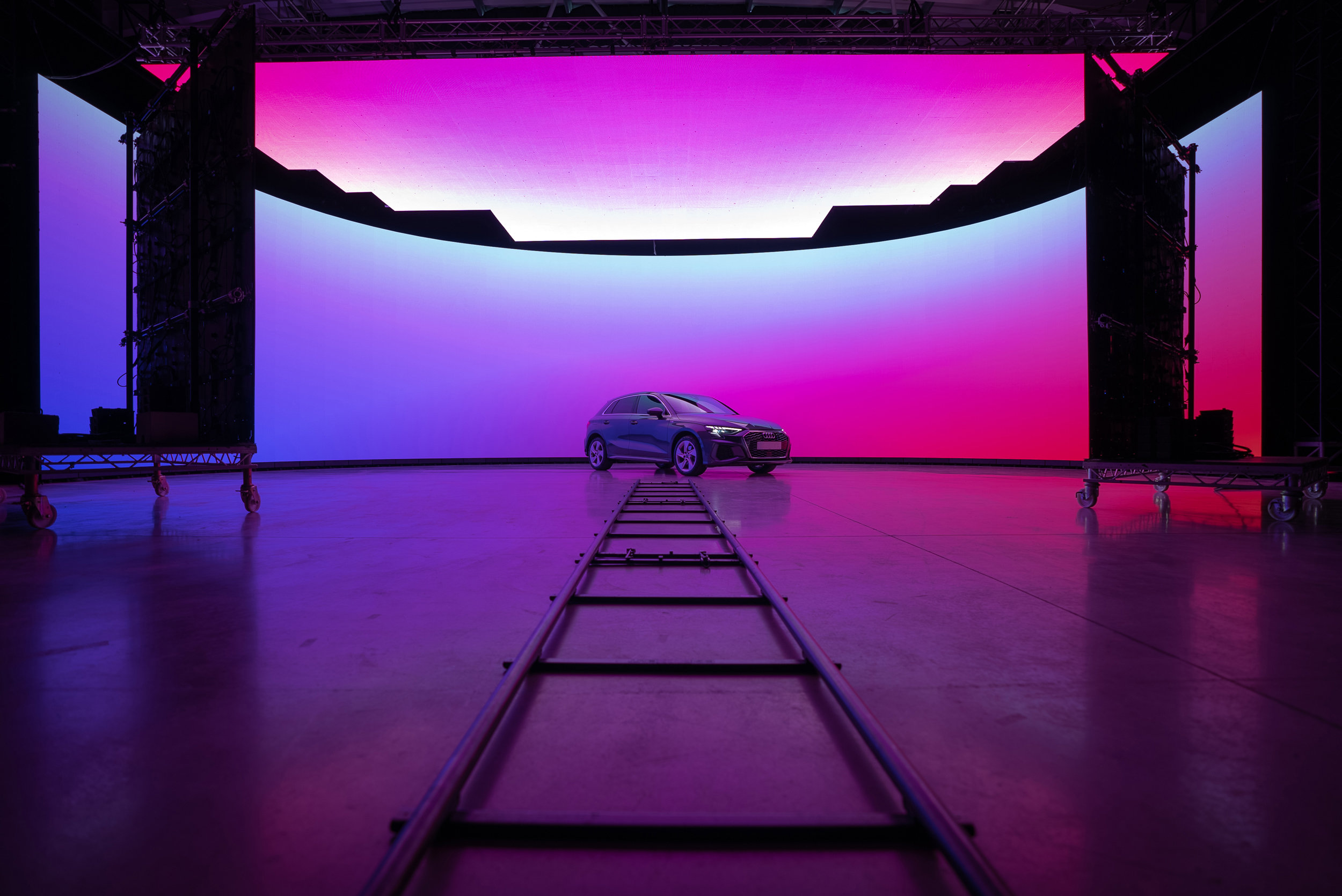 A car is in front of a huge virtual production screen