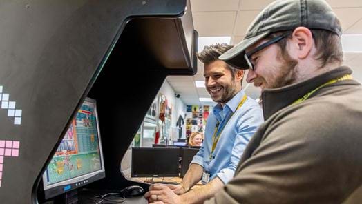Two men gaming on an arcade machine