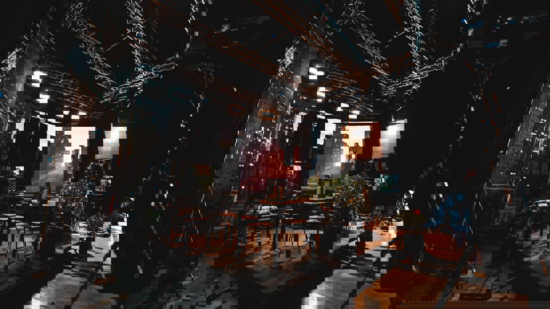 A  fictional living room in front of a virtual production screen showing a skyscraper background