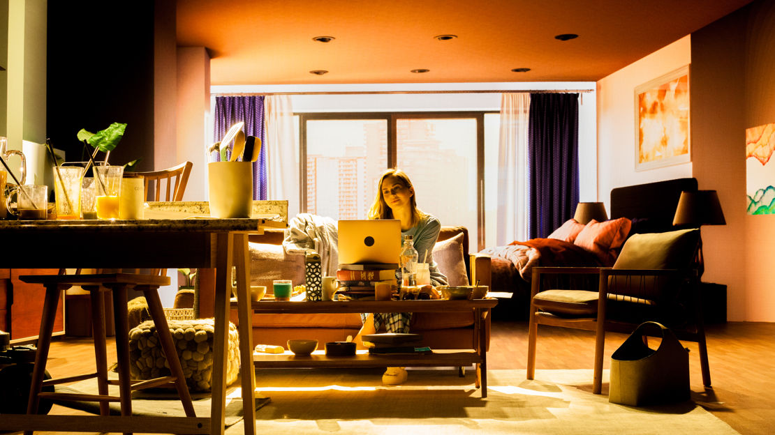 Actor in a virtual production set with a screen in the background showing the inside of a room