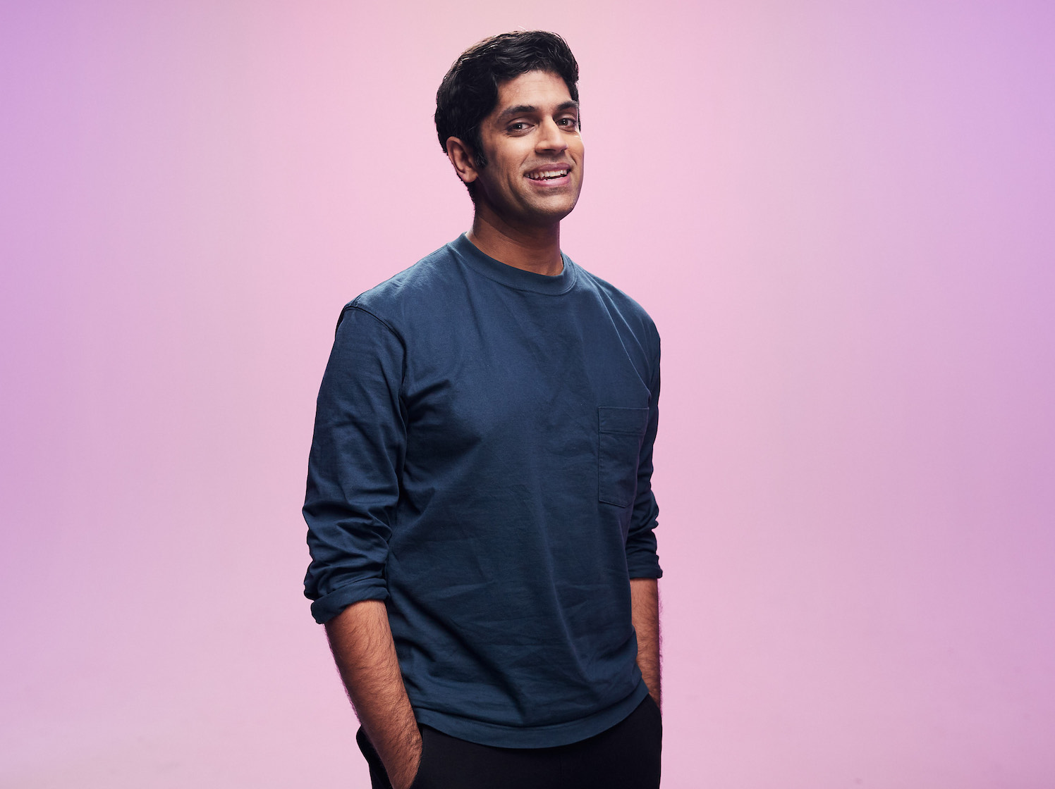 Faraz Osman stands in front of a pink background