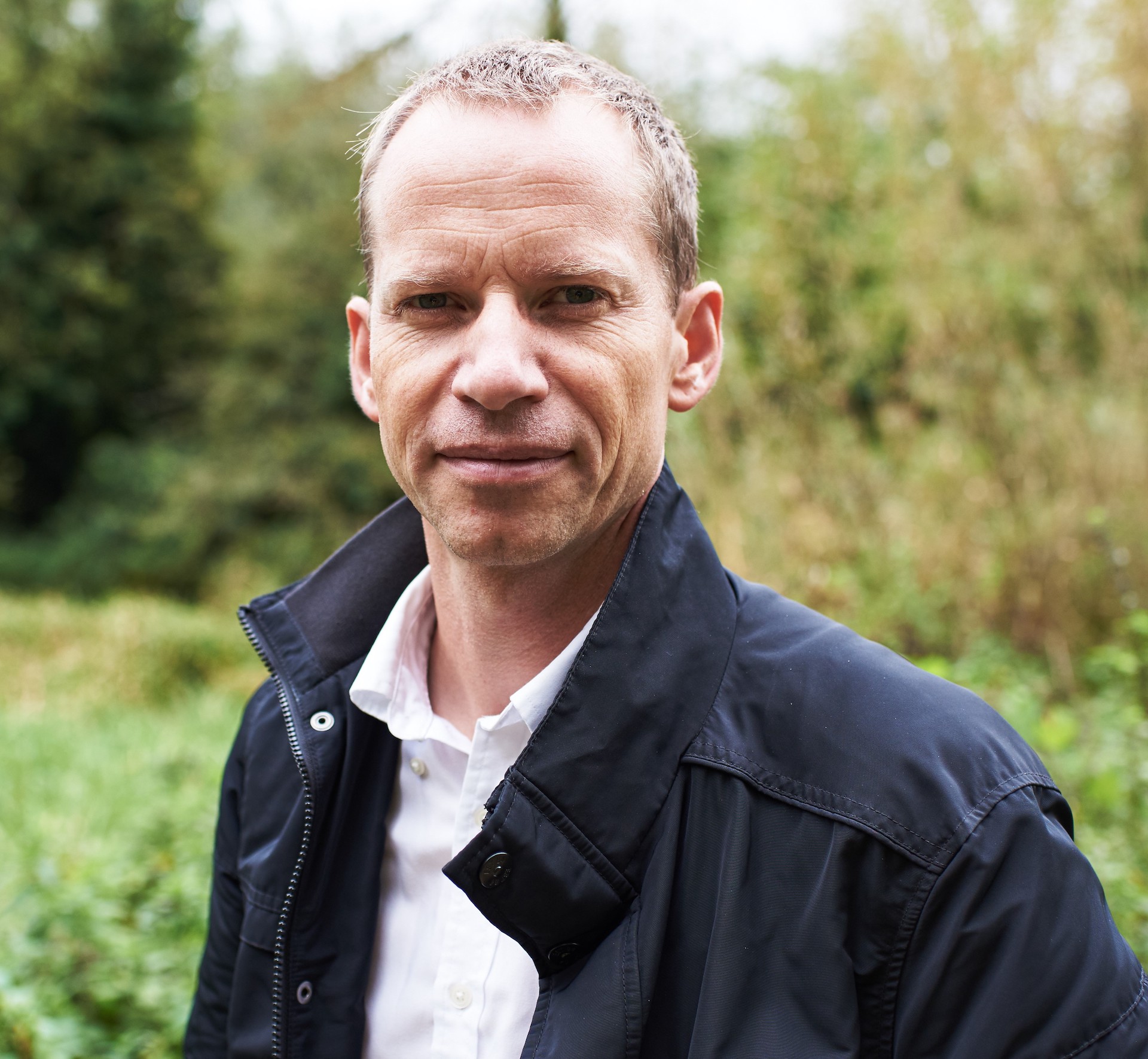 Close up image of Charlie Gauvain against a background of trees