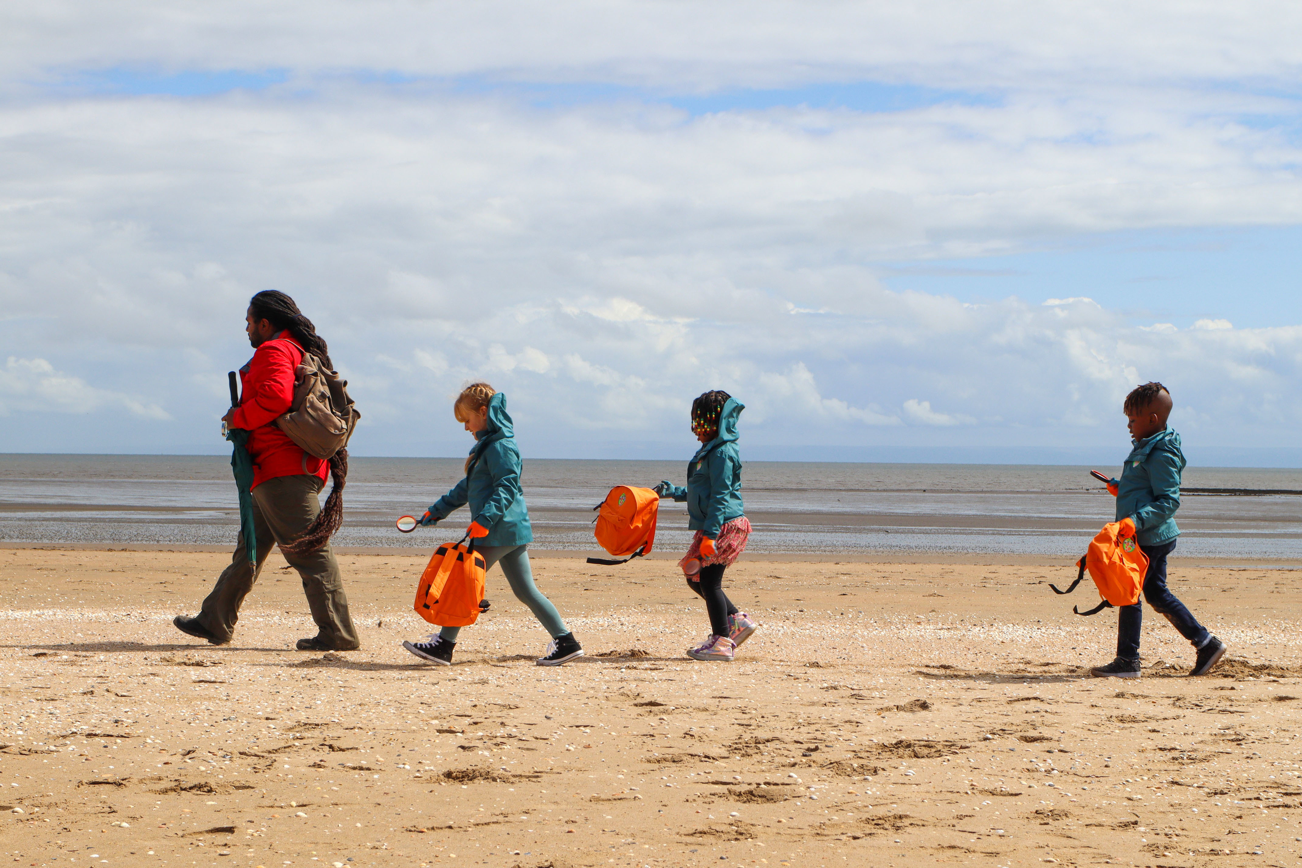 Production shot from Ranger Hamza's Eco Quest S2 of Ranger Hamza (Hamza Yassin) and his three young ramblers march along the beach