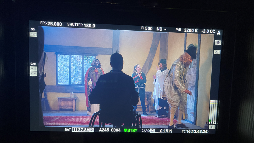 A screen showing a group of actors dressed in medieval clothes shooting a scene