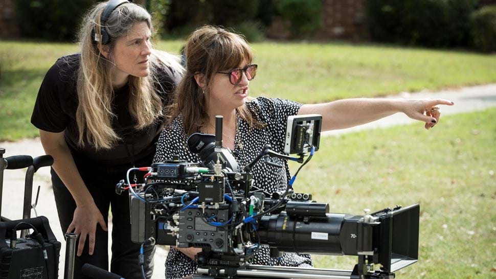 Behind-the-scenes shot of Black Widow director Cate Shortland pointing from behind a camera with a sound colleague standing behind