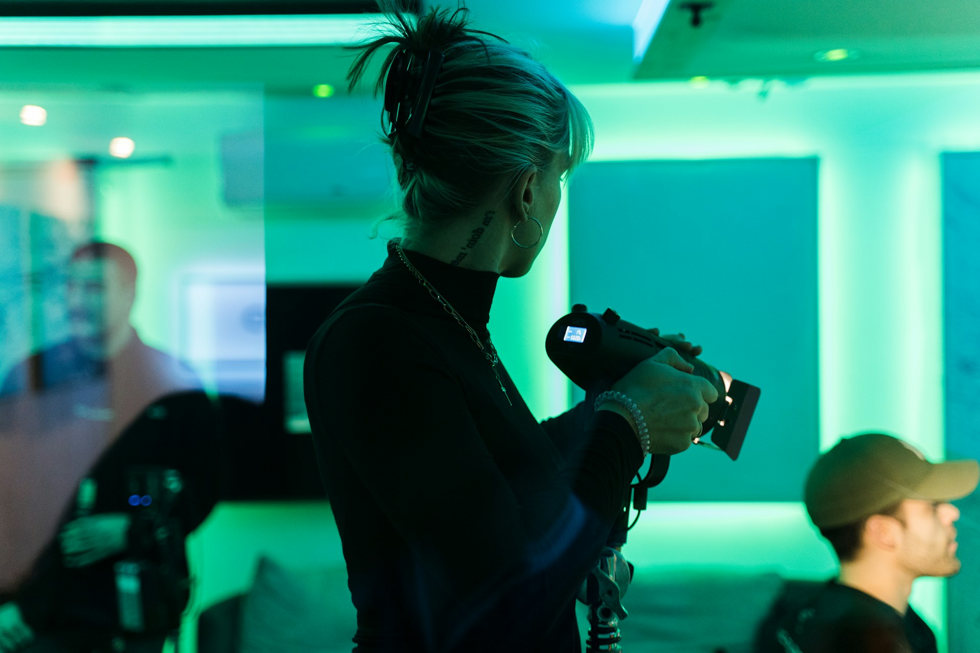 A photo of a woman adjusting a lighting fixture on set