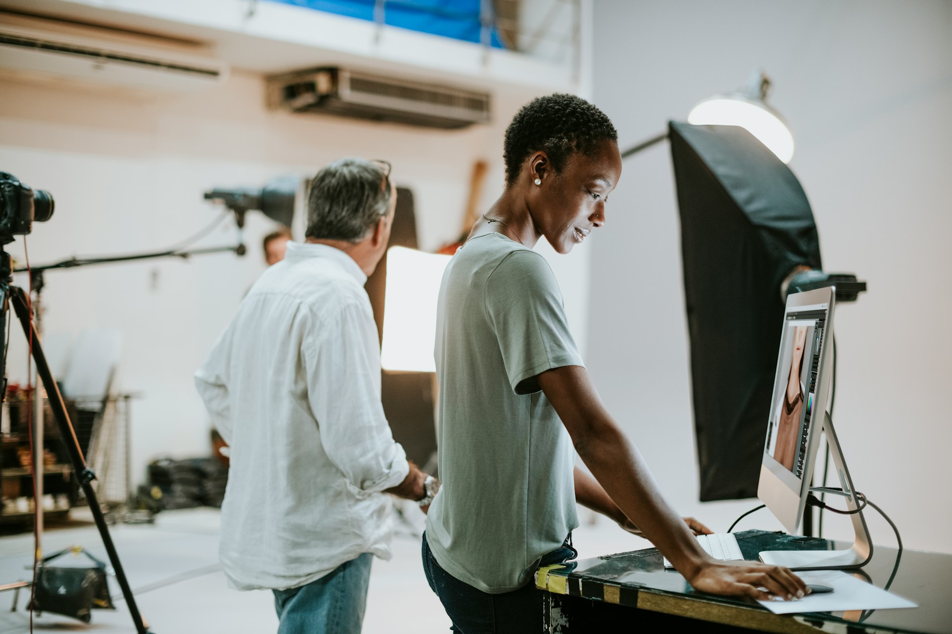 A woman on set looks at a desktop monitor