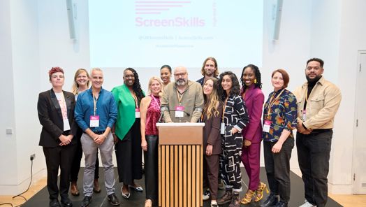 Group photo of the Leaders of Tomorrow cohort one standing around a lectern at their graduation ceremony