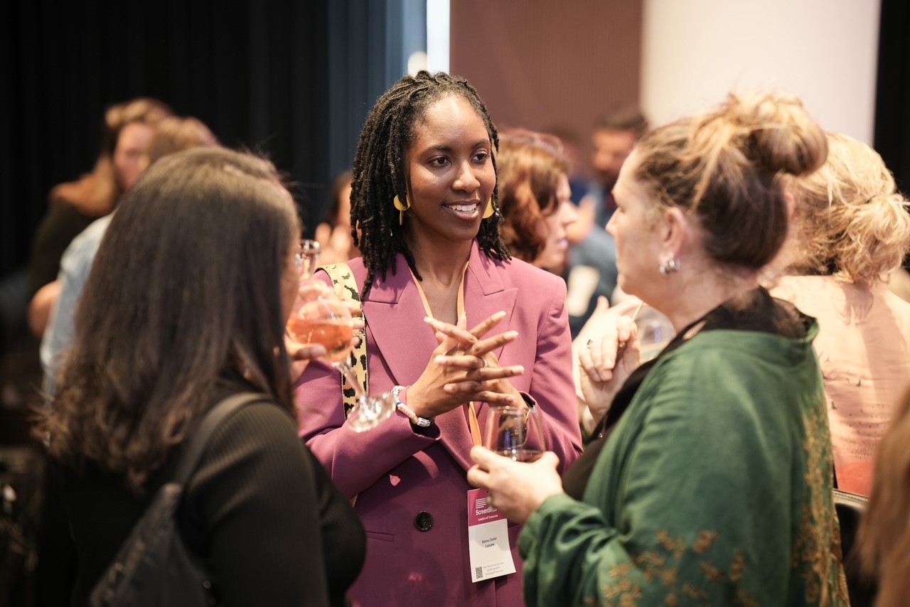 Graduating candidate Rianna Charles smiles as she speaks with two other guests at the Leaders of Tomorrow graduating event in London
